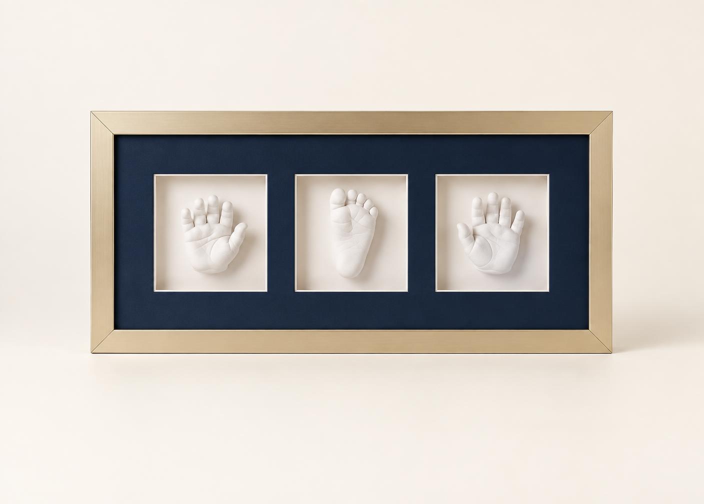 Three-window champagne gold frame with navy mount holding three 3D impressions, shown complete